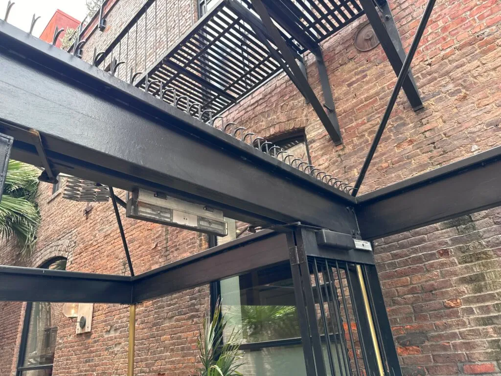 Lighting fixture under the beam and Ninja Deterrent™ spikes above it.