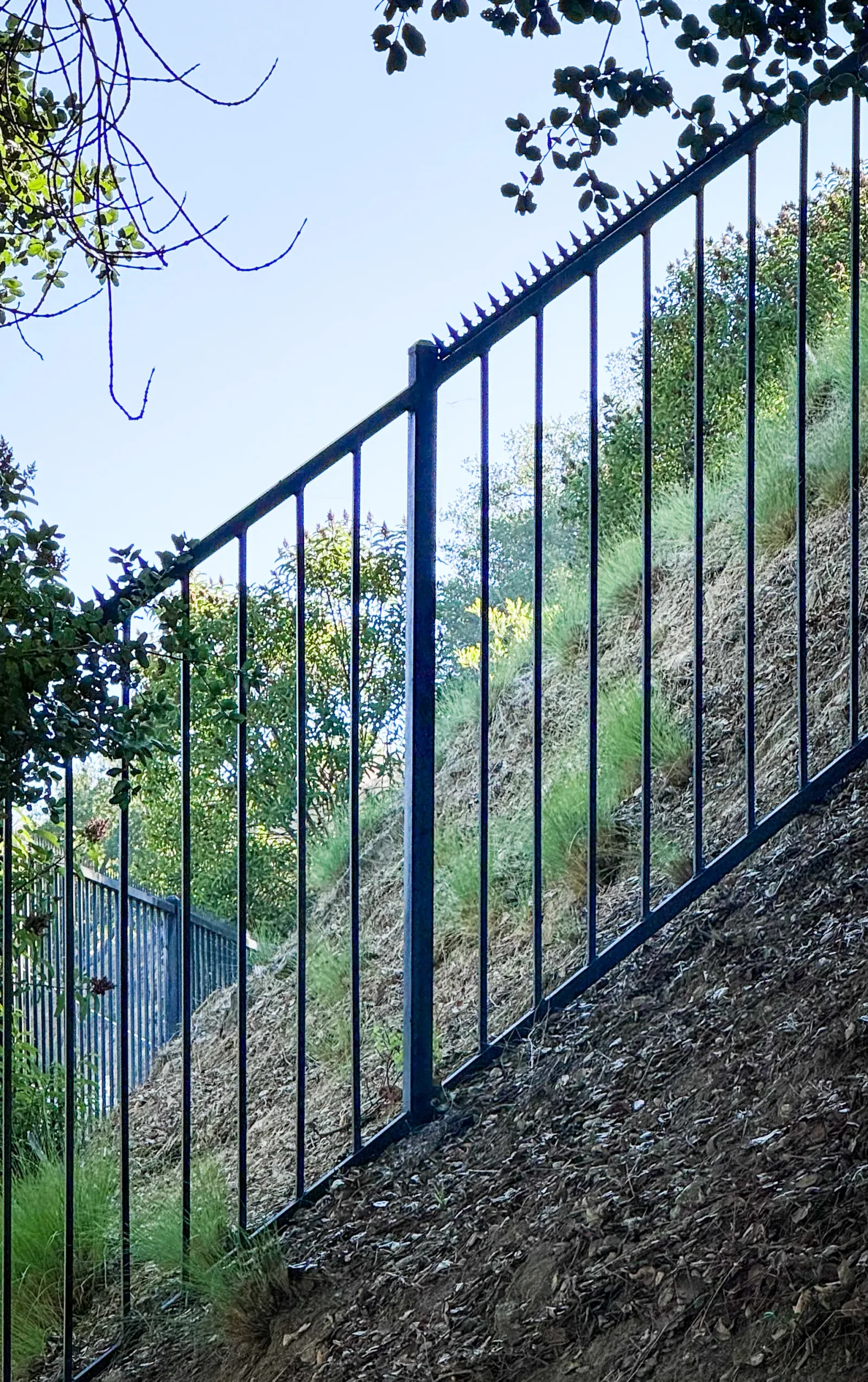 Hilly fence seen from an oblique angle. Details of the Gothic (Black) on the top edge.
