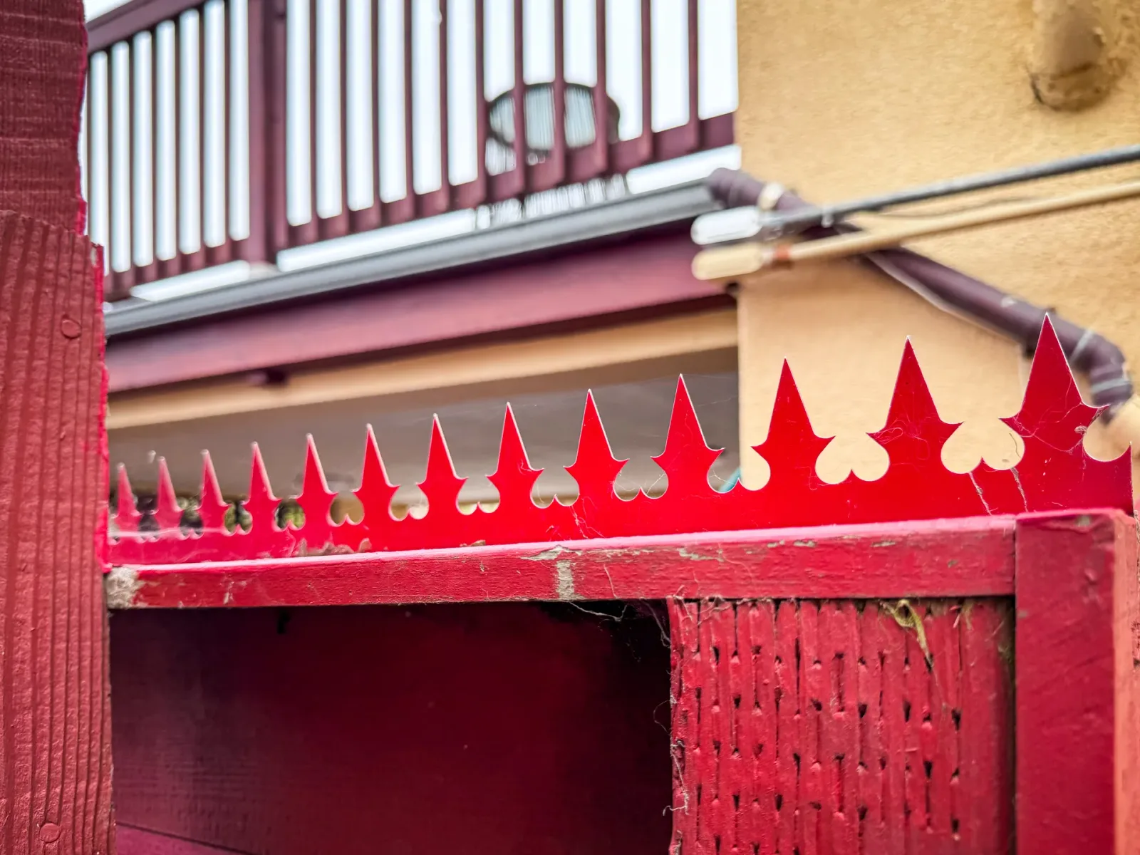 Detail der Zaunecke. Das Bild zeigt das Verhältnis zwischen den roten Spikes und der angrenzenden Außenwand.