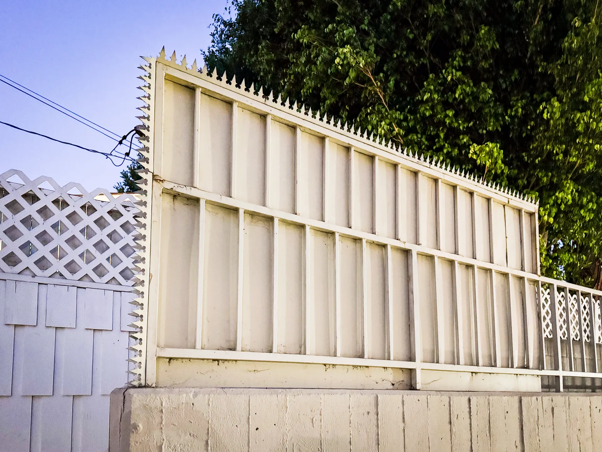 Wide night view of the spiked perimeter wall around the property