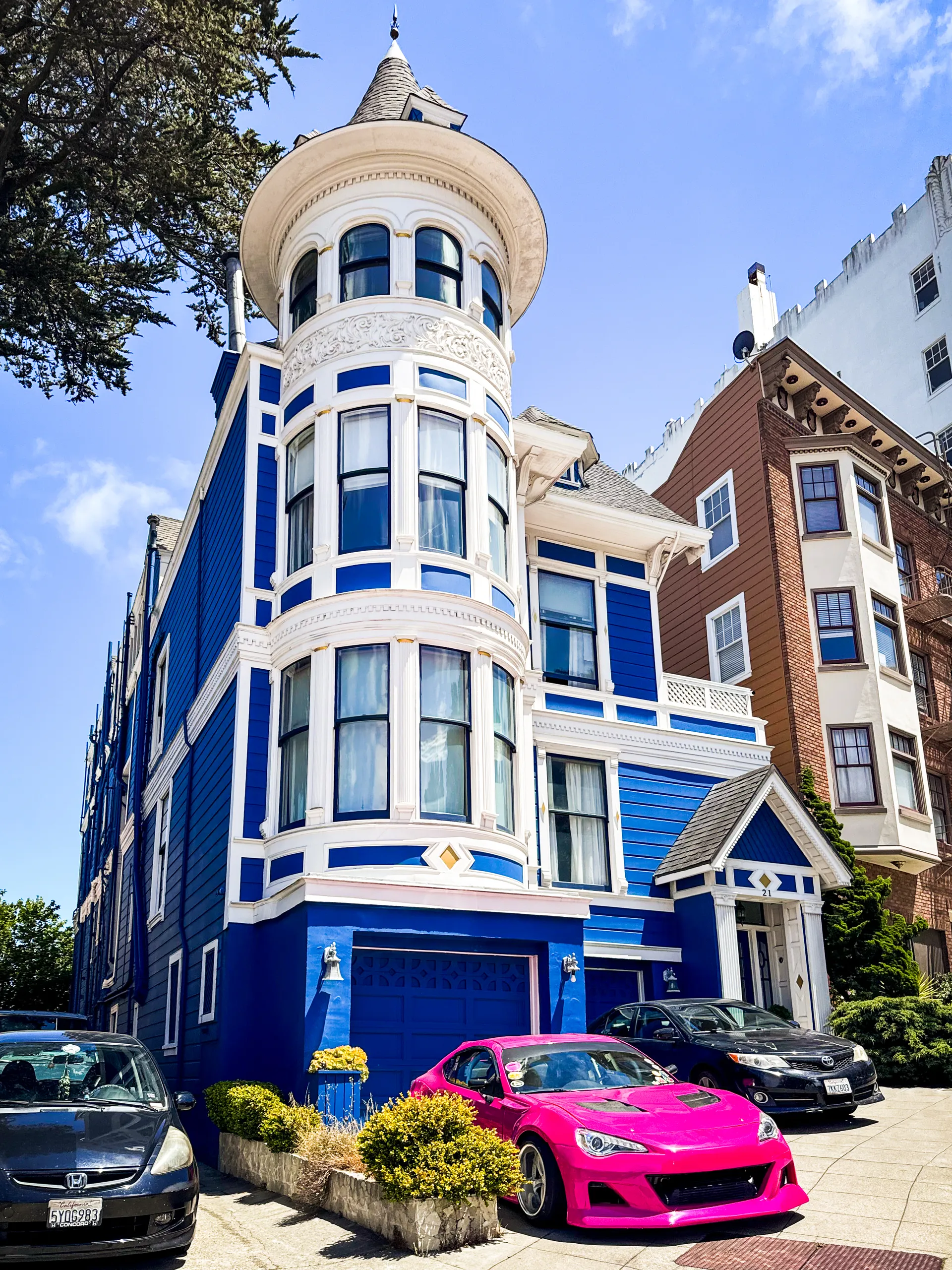 Blue clapboard facade with ornate white trim and the protected fence line below the window