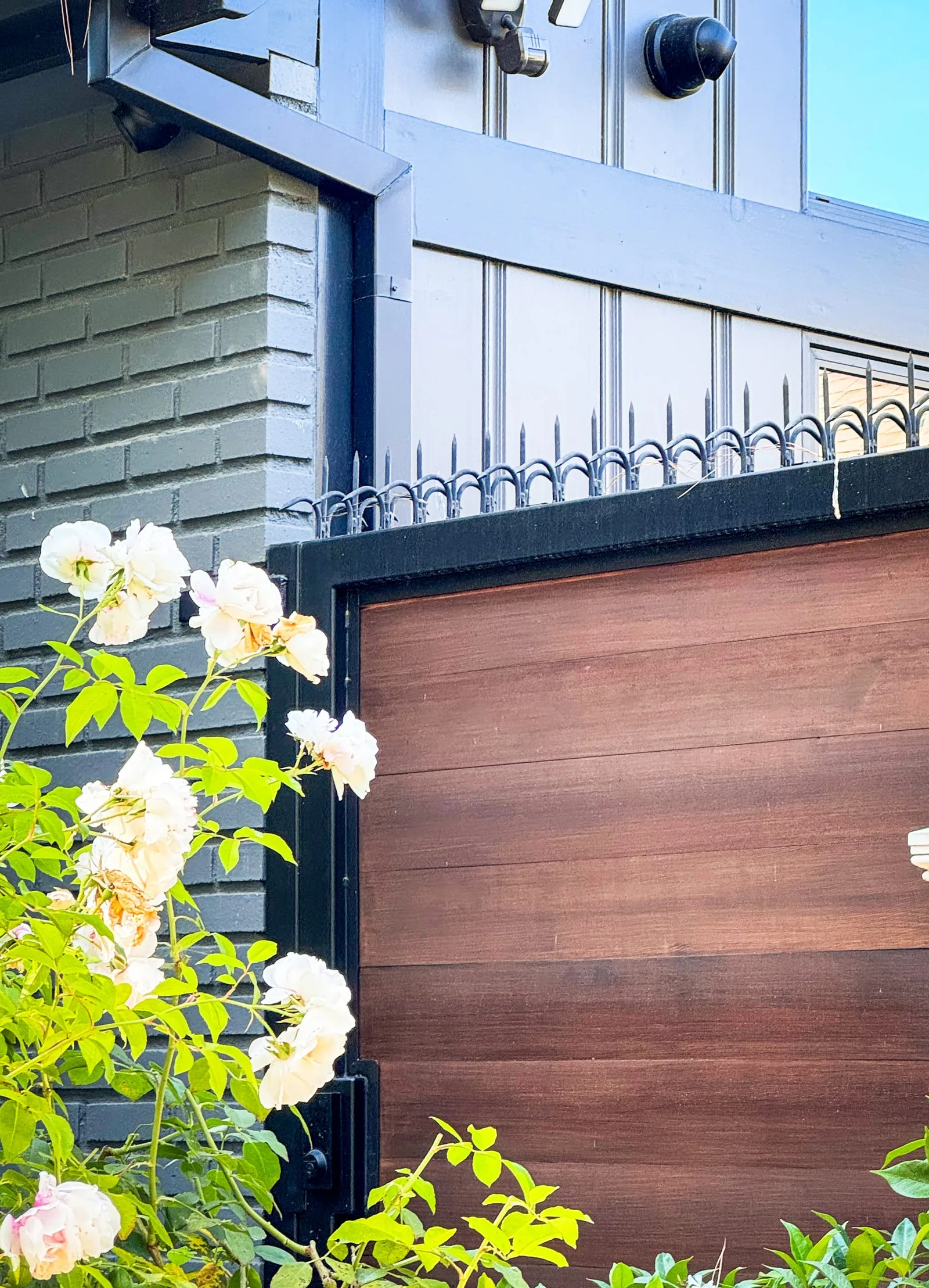 Close view of anti-climb deterrent on a modern front gate with wood panel infill.