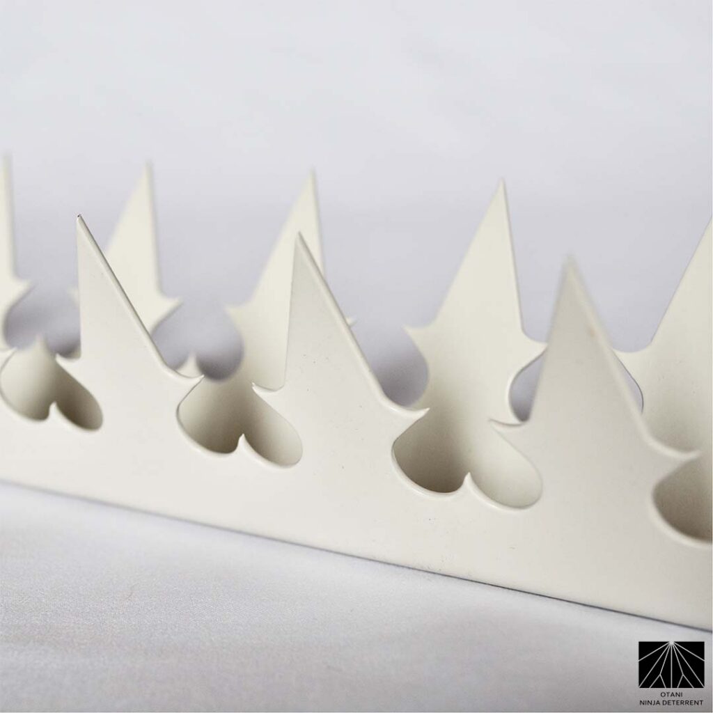 Close-up of GIZAGIZA white dual heart security spikes with sharp triangular blades – Japanese-made minimalist deterrent for modern architecture