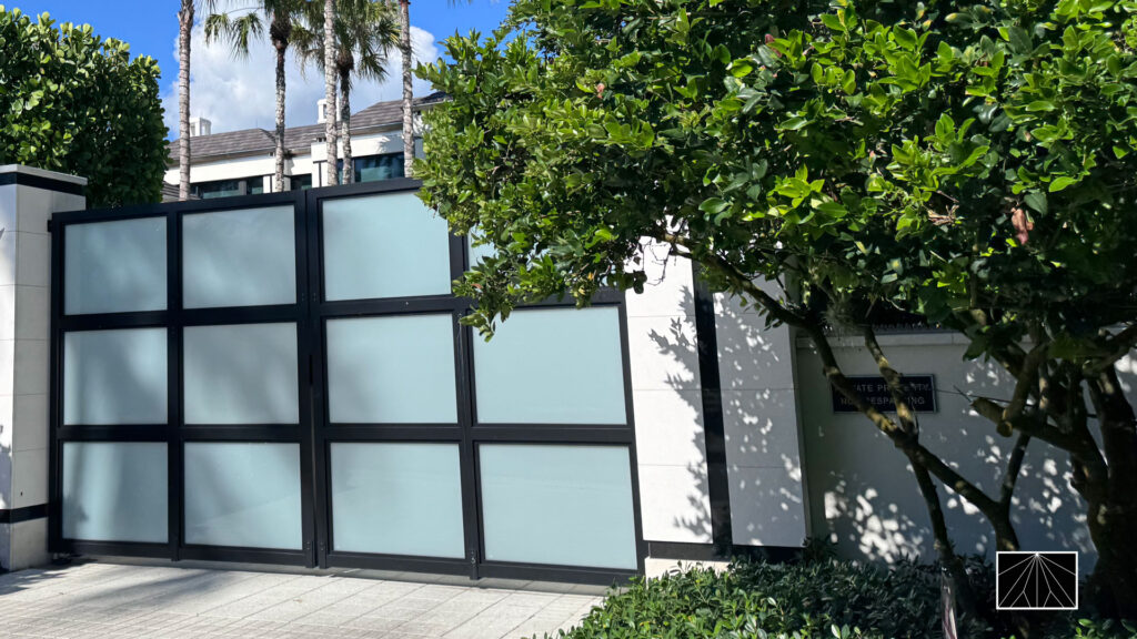 Ninja Deterrent™ anti-climb spikes installed on a modern frosted-glass gate of a luxury residence, combining privacy, design, and security.