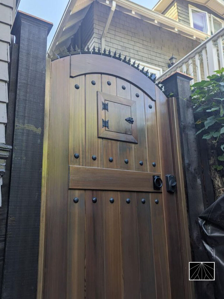 Arched wooden gate fitted with Ninja Deterrent™ anti-climb spikes, blending architectural craftsmanship and discreet home security