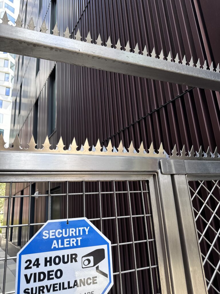 Puerta de seguridad con puntas de acero y señal de vigilancia en San Francisco.