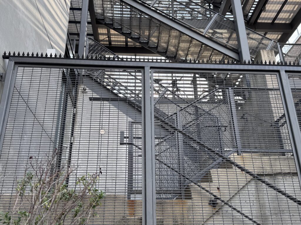 Cerramiento de seguridad con rejilla metálica y estructura de acero de estilo industrial.