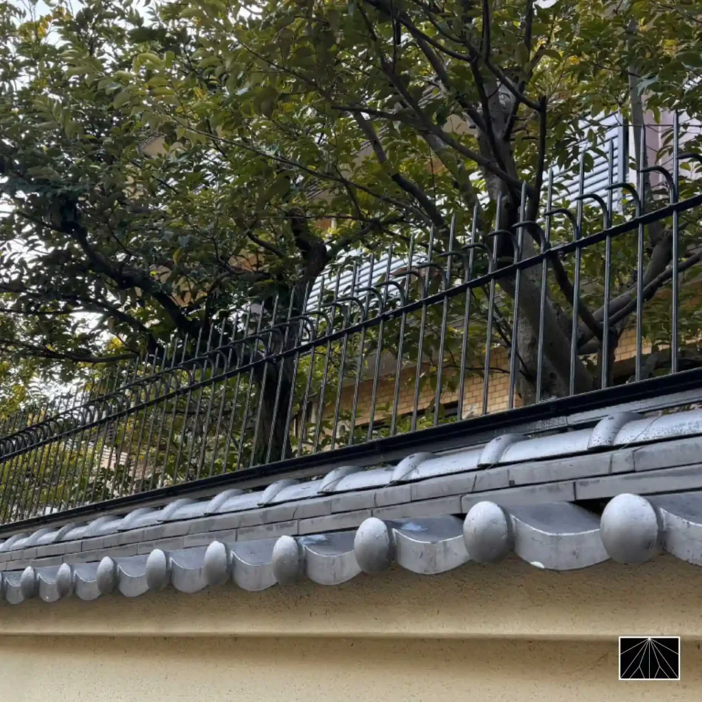 Barrera de seguridad Ninja Deterrent Classic en color negro, instalada sobre un muro tradicional japonés con tejas, integrando protección moderna y estética clásica.