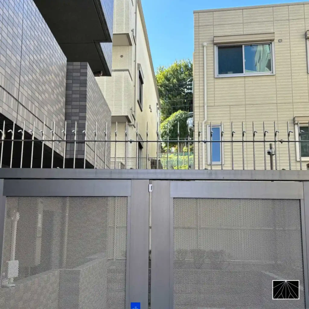 现代住宅区金属大门頂部の銀色防盗刺，专业级 Ninja Deterrent 周界安全方案。