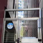 Barrera de seguridad Ninja Deterrent Gothic en acero inoxidable instalada sobre un portón de seguridad urbano, ofreciendo una protección física duradera y elegante.