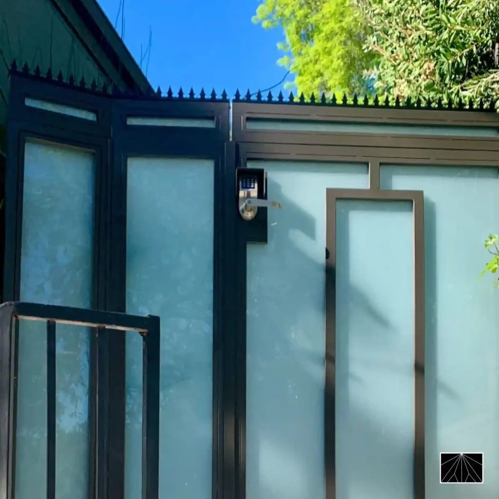 Espigões de segurança Ninja Deterrent Gothic em inox preto instalados em portão metálico moderno para segurança urbana.