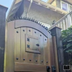 럭셔리한 아치형 나무 대문에 설치된 닌자 디터런트 고딕 장식용 방범 가시 - 품격 있는 디자인의 침입 방지 시스템.