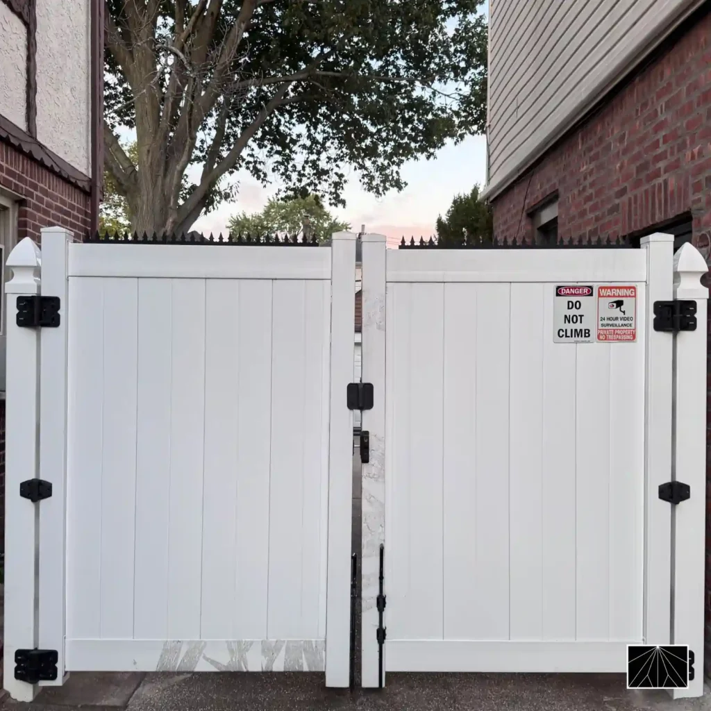 Piques anti-escalade Ninja Deterrent Gothic noirs sur un portail en vinyle blanc avec un panneau d'avertissement pour une sécurité maximale.