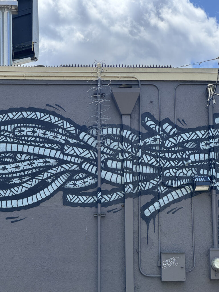 Fil barbelé de type concertina au-dessus de la fresque, avec conduit extérieur et luminaire mural