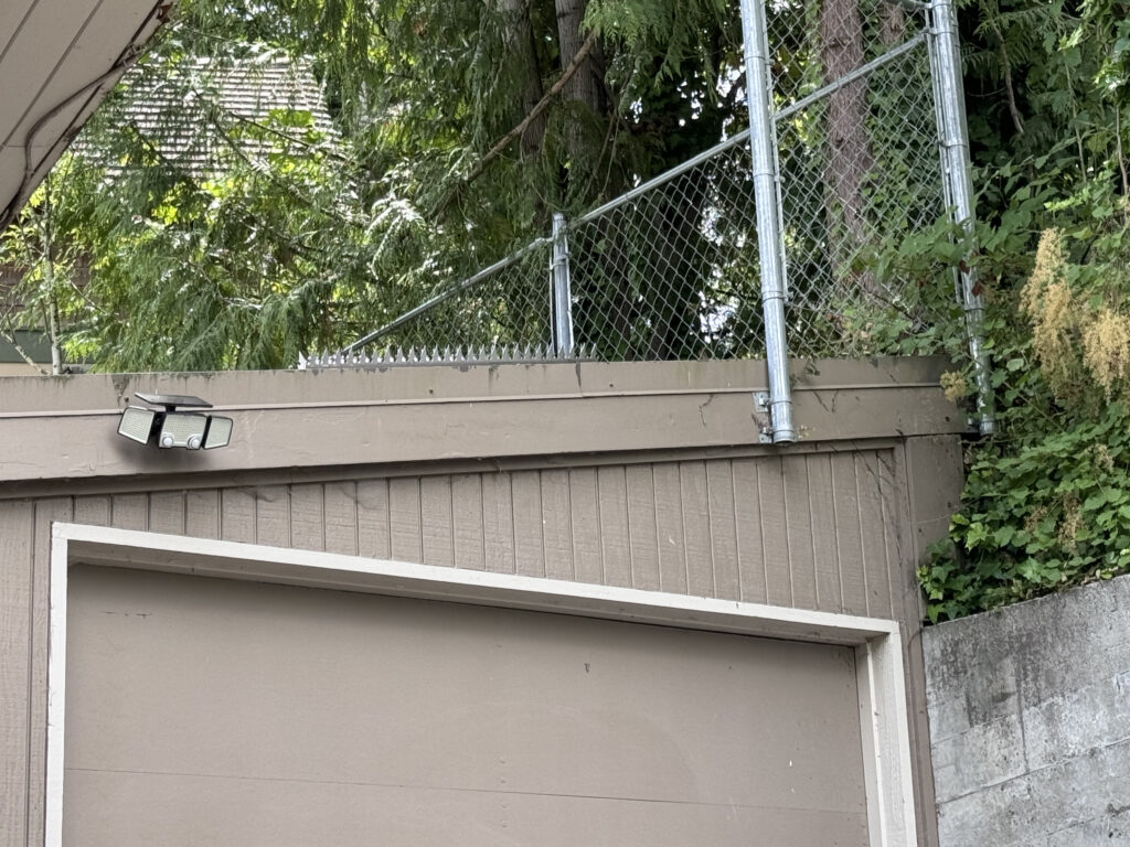 シアトルの住宅で、ガレージ壁面に取り付けられたフェンス／壁用スパイク（Fence wall spikes）。Ninja Deterrent™ の防犯ソリューション。