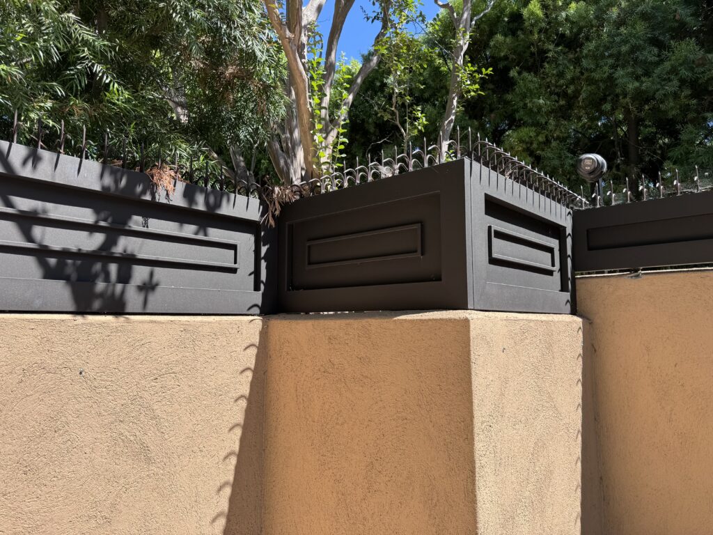 Corner of the entry fence line with anti-climb spikes and security cameras above the perimeter
