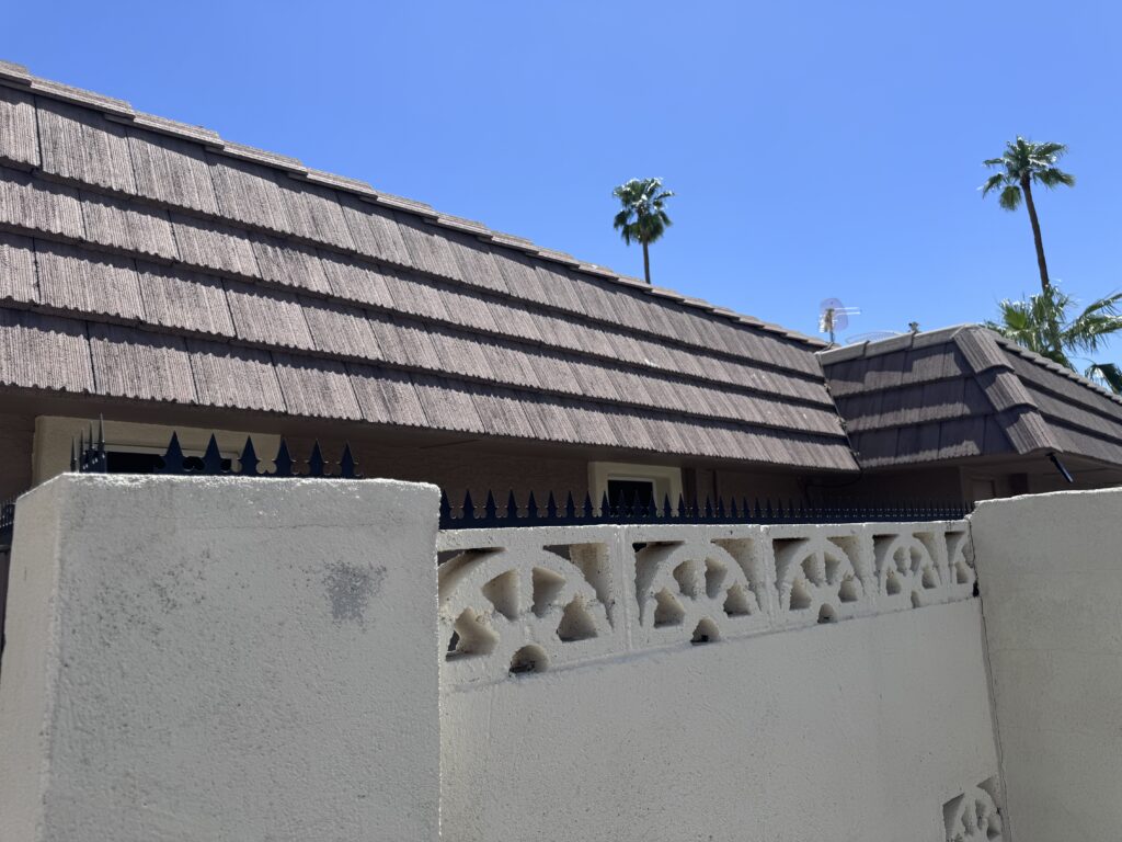 Close view of Gothic spikes installed on a stucco wall, aligned in a continuous run near decorative iron windows.