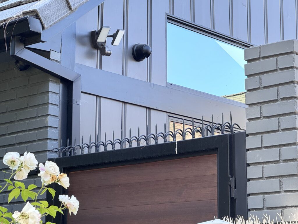 Portão frontal moderno de madeira e metal em Westwood com dissuasor anti-escalada (Gothic/Black) instalado ao longo da borda superior.