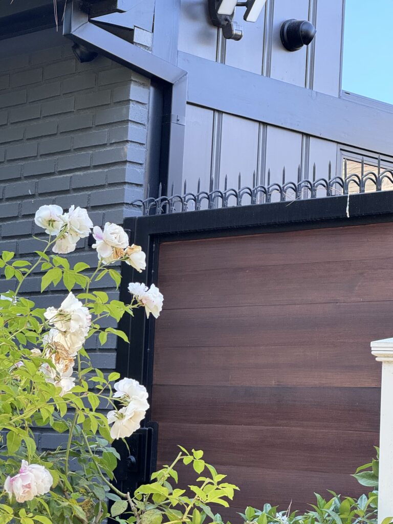 Vue rapprochée du dissuasif anti-escalade (Gothic/Black) sur un portail moderne avec remplissage en bois.