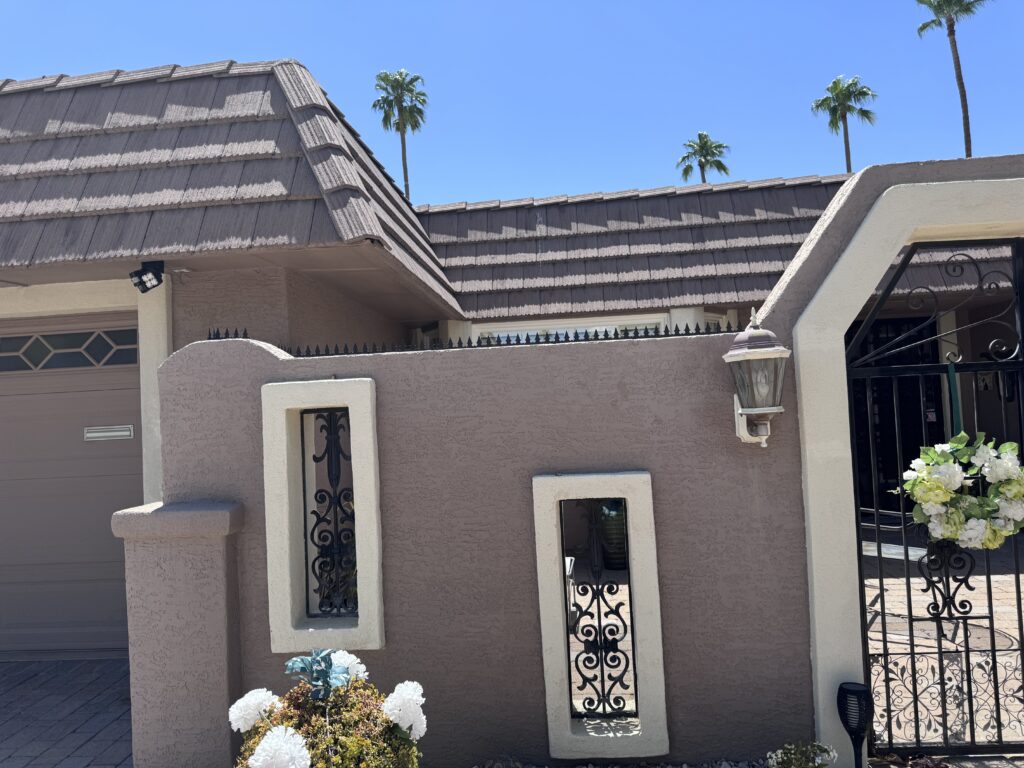 Residencia tranquila en Phoenix con muro de estuco, rejas de hierro forjado y púas Gothic a lo largo del borde superior.