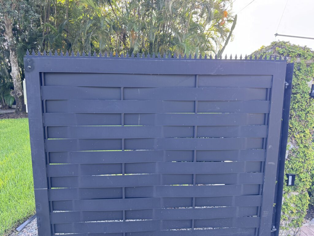 검은 가로 슬랫 금속 게이트 상단의 안티클라임 스파이크 디테일 클로즈업