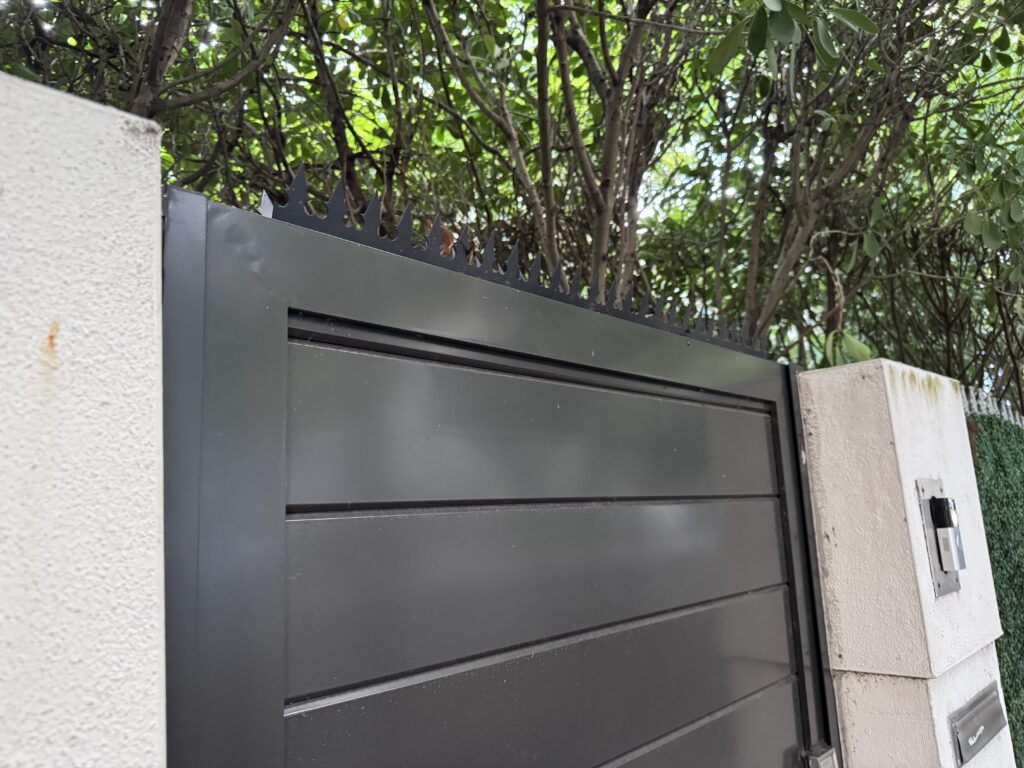 Détail en angle : pics anti-escalade Gothic installés sur le cadre supérieur d’un portail d’entrée noir à Miami Beach