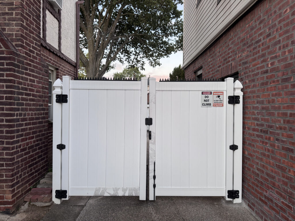 Weißes Vinyl-Doppeltor, oben mit Ninja Deterrent™ Anti-Climb-Spikes verstärkt